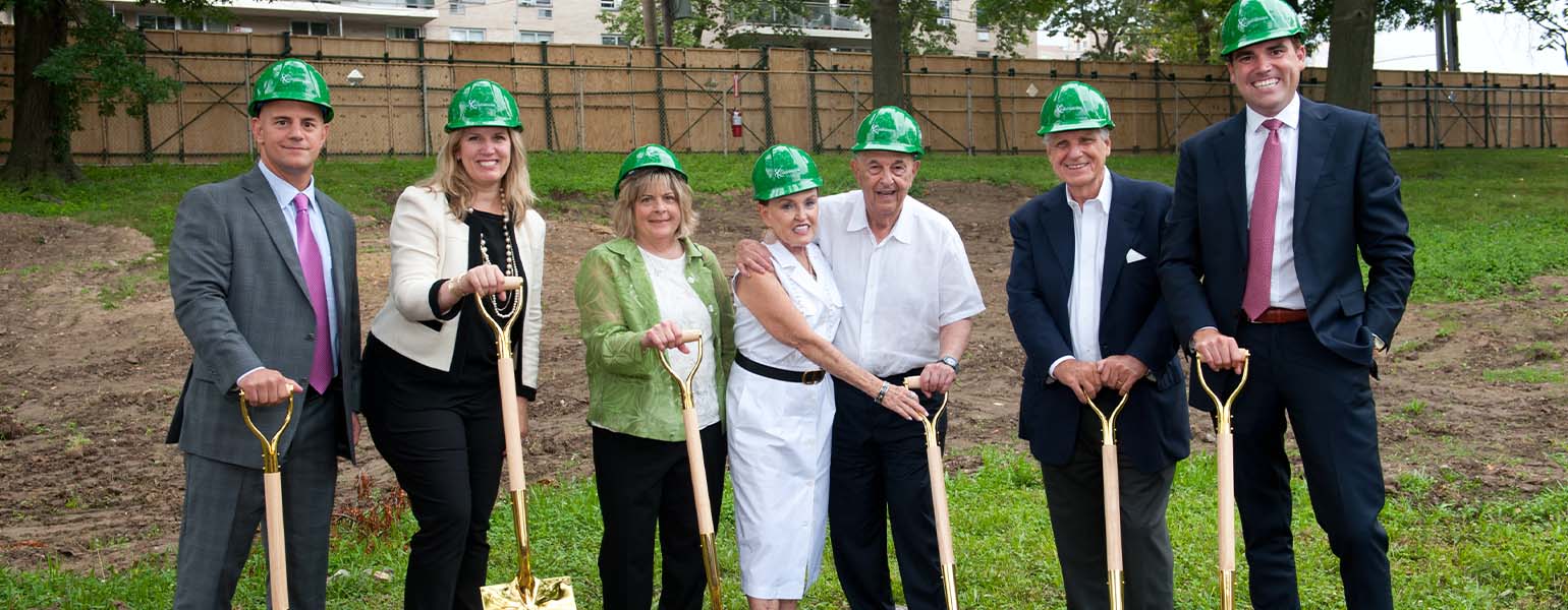 People with hard hats and shovels at a groundbreaking ceremony